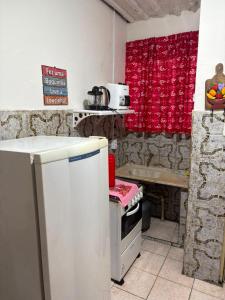 a kitchen with a refrigerator and a table in it at Casa a 3 minutos da basilica in Aparecida