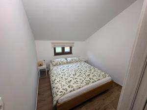 a white bedroom with a bed and a window at Babina Hiža in Pula