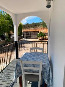 a table and a white chair on a balcony at Luciano Rooms in Ksamil