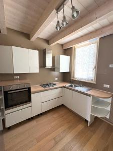 a kitchen with white cabinets and a sink and a window at Dimora Dell Olmo in Civitanova Marche