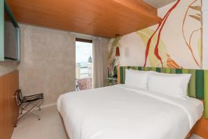 a bedroom with a large white bed and a window at Motto By Hilton Recife in Recife