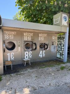 a gas station with three washing machines in it at Mobilheim Chalet bei Georg in Seekirchen am Wallersee
