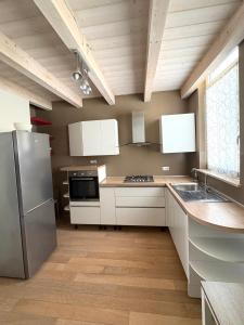 a kitchen with white cabinets and stainless steel appliances at Dimora Dell Olmo in Civitanova Marche +22 photos
