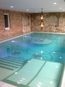 a large swimming pool in a building at Hillside Olive Apartmanház közös WELLNESsell in Pécs
