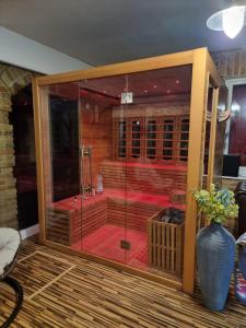 a shower in a room with a glass door at Hillside Olive Apartmanház közös WELLNESsell in Pécs