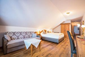salon z łóżkiem i kanapą w obiekcie Hotel Bergjuwel w Neustift im Stubaital
