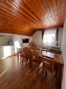 a dining room with a large wooden table and chairs at Apartmány Ve Mlejně in Čachrov