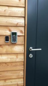 a door with a cell phone on a wooden wall at Cottage2Rest in Erbach