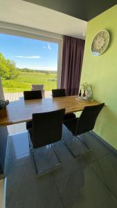 a dining room table with chairs and a clock on the wall at Cottage2Rest in Erbach