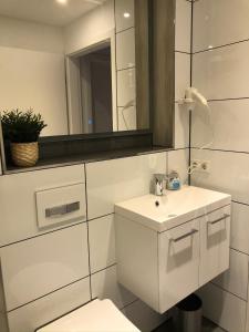 a white bathroom with a sink and a mirror at Cottage2Rest in Erbach +118 photos