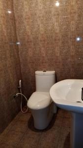 a bathroom with a white toilet and a sink at Breeze Mahagedara in Nuwara Eliya
