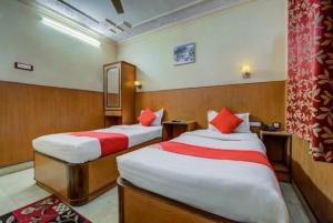 a hotel room with two beds with red pillows at HOTEL Embassy in Rānchī +14 photos