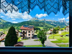 a view from a window of a town with mountains at Alpen Family Hotel Someda in Moena