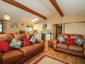 a living room with two leather couches and a kitchen at Valley View Lodge in Trelystan +31 photos