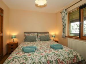 a bedroom with a large bed with green pillows at Valley View Lodge in Trelystan