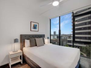 a bedroom with a white bed and a large window at The Sebel Residences Melbourne Docklands Serviced Apartments in Melbourne +90 photos