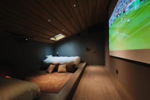 a bedroom with two beds and a large screen at THE THIRD PLACE Mt Fuji in Fujikawaguchiko