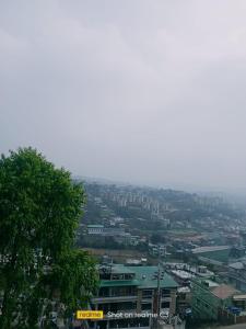 a view of a city with buildings and a tree at Serene Lodge in Shillong
