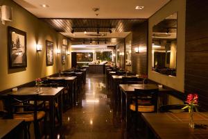 a restaurant with tables and chairs in a room at Royal Collection Paulista in São Paulo