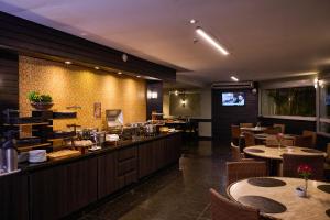 a restaurant with tables and chairs and a bar at Royal Collection Paulista in São Paulo