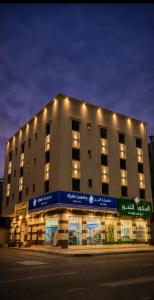 a large building with lights on top of it at سجى الهدوء للشقق المخدومة in Abha