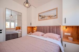 a bedroom with a large bed with pink pillows at Apartments Bonex in Privlaka +180 photos