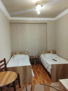 a room with two beds and a table in it at temuri Room 558-58-78-27 in Poti