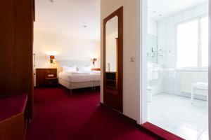 a hotel room with a bed and a bathroom at Romantik Hotel zur Sonne in Badenweiler