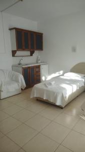 a bedroom with a large bed and a kitchen at Marigold Otel in Çeşme