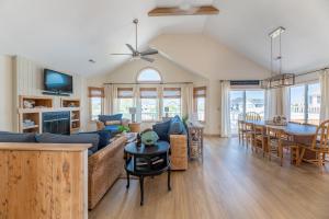 a living room with a blue couch and a table at Into the Sun - Corolla, Villages at Ocean Hill, 75 Yds to Beach, Hot Tub, Community Pool, Pets OK, Flex Stays in Corolla