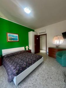 a green bedroom with a bed and a green wall at Lincoln B&B in Caserta