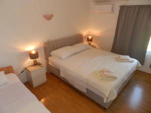 a bedroom with a bed and two lamps on tables at Apartments Lea in Orebić