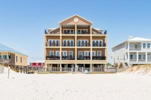 a large building on the beach next to the sand at Luxury Beachfront Duplex in Fort Morgan - Pool Elevator and Wedding-Friendly in Gulf Shores