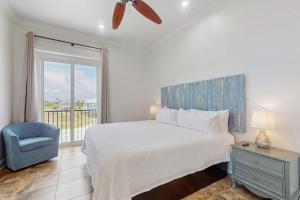 a bedroom with a bed and a chair and a window at Luxury Beachfront Duplex in Fort Morgan - Pool Elevator and Wedding-Friendly in Gulf Shores