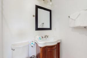a bathroom with a sink and a mirror on the wall at Luxury Beachfront Duplex in Fort Morgan - Pool Elevator and Wedding-Friendly in Gulf Shores +29 photos