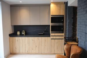 a kitchen with white cabinets and black counter tops at MoV Flexliving in Oviedo