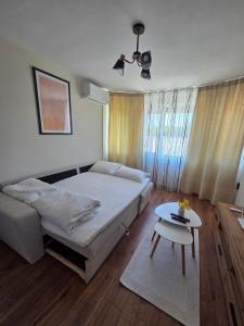 a bedroom with a bed and a table in it at White House Apartments - Boho in Haskovo