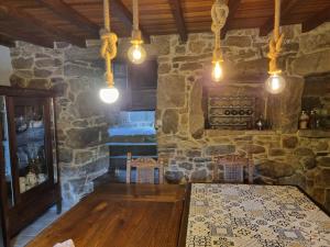 a room with a table and a stone wall at Casa Gasamáns in Amés +37 photos