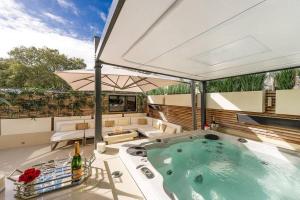 a hot tub on a patio with an umbrella at MariaHilferHome in Vienna