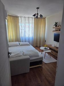 a bedroom with a large bed and a desk at White House Apartments - Boho in Haskovo