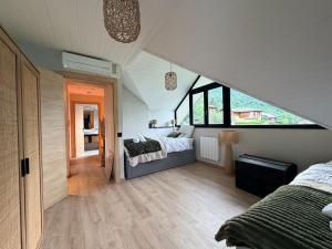 a attic bedroom with two beds and a staircase at La Maison Du Lac in Doussard