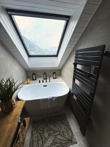 a bathroom with a large window and a bath tub at La Maison Du Lac in Doussard +58 photos