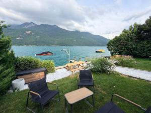 a group of chairs and a table next to a lake at La Maison Du Lac in Doussard