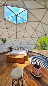 a bedroom in a tent with a bed and a table at Amatea de Villa de Leyva in Villa de Leyva
