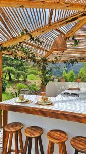 a kitchen with a counter with stools and a table at Amatea de Villa de Leyva in Villa de Leyva