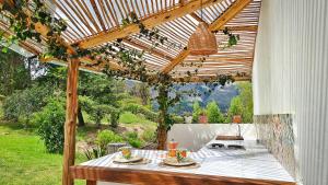a wooden pergola with a table with food on it at Amatea de Villa de Leyva in Villa de Leyva