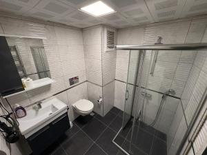 a bathroom with a shower and a toilet and a sink at Saklıkonak Otel in Isparta +25 photos