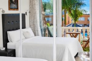 a bedroom with a white bed and a window at Villa Gisel in La Playa de Tauro +18 photos