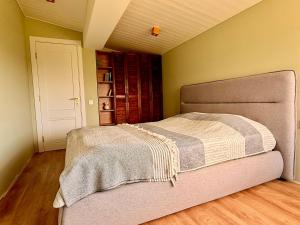 a bedroom with a bed with a blanket on it at Guesthouse near Tbilisi in Saguramo