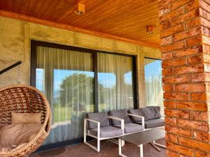 a porch with two chairs and a wicker couch at Guesthouse near Tbilisi in Saguramo +6 photos